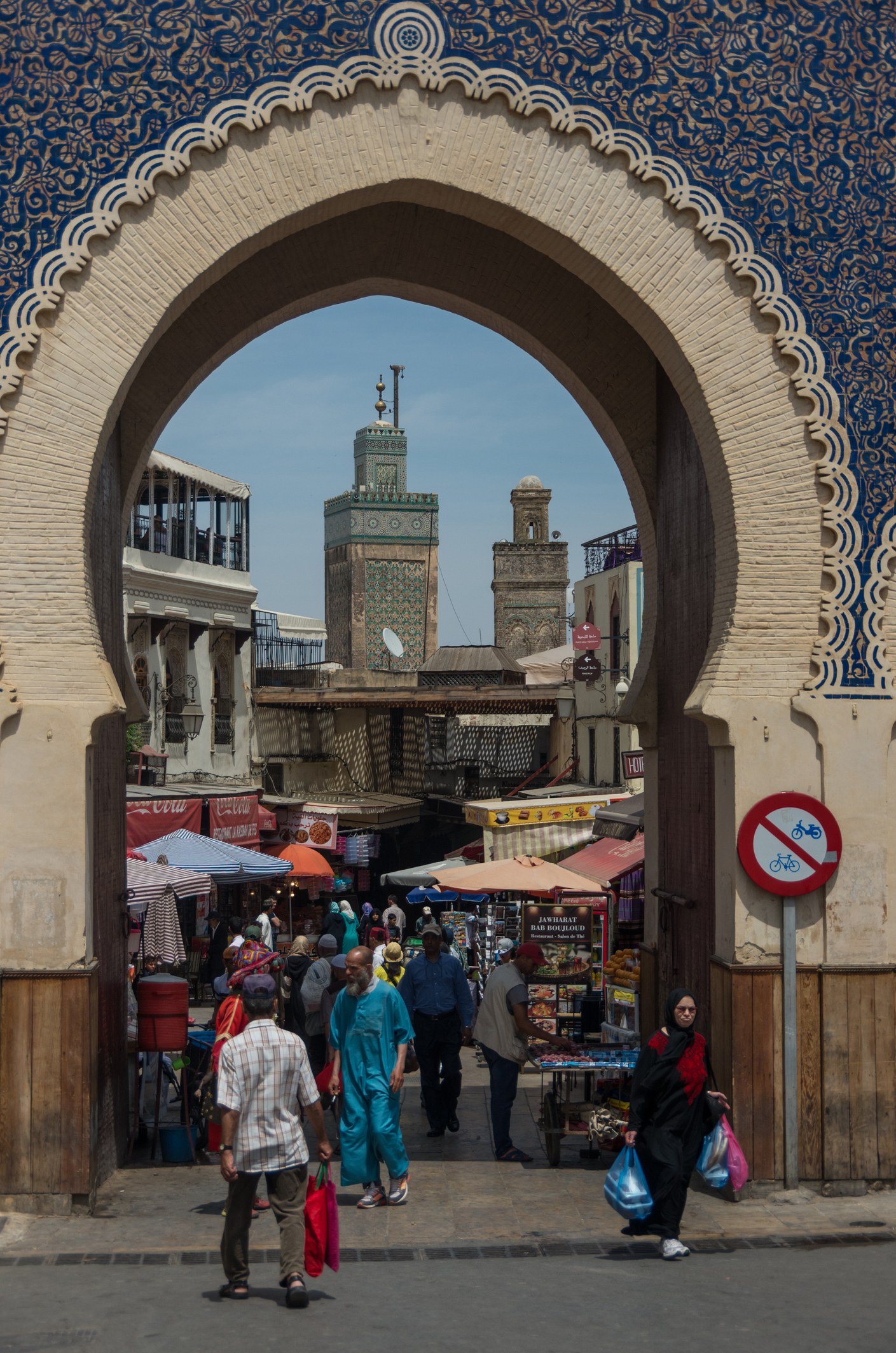 Puerta Bab Bou Jeloud de Fez con arco de yesería azul y minaretes al fondo, entrada a la medina UNESCO