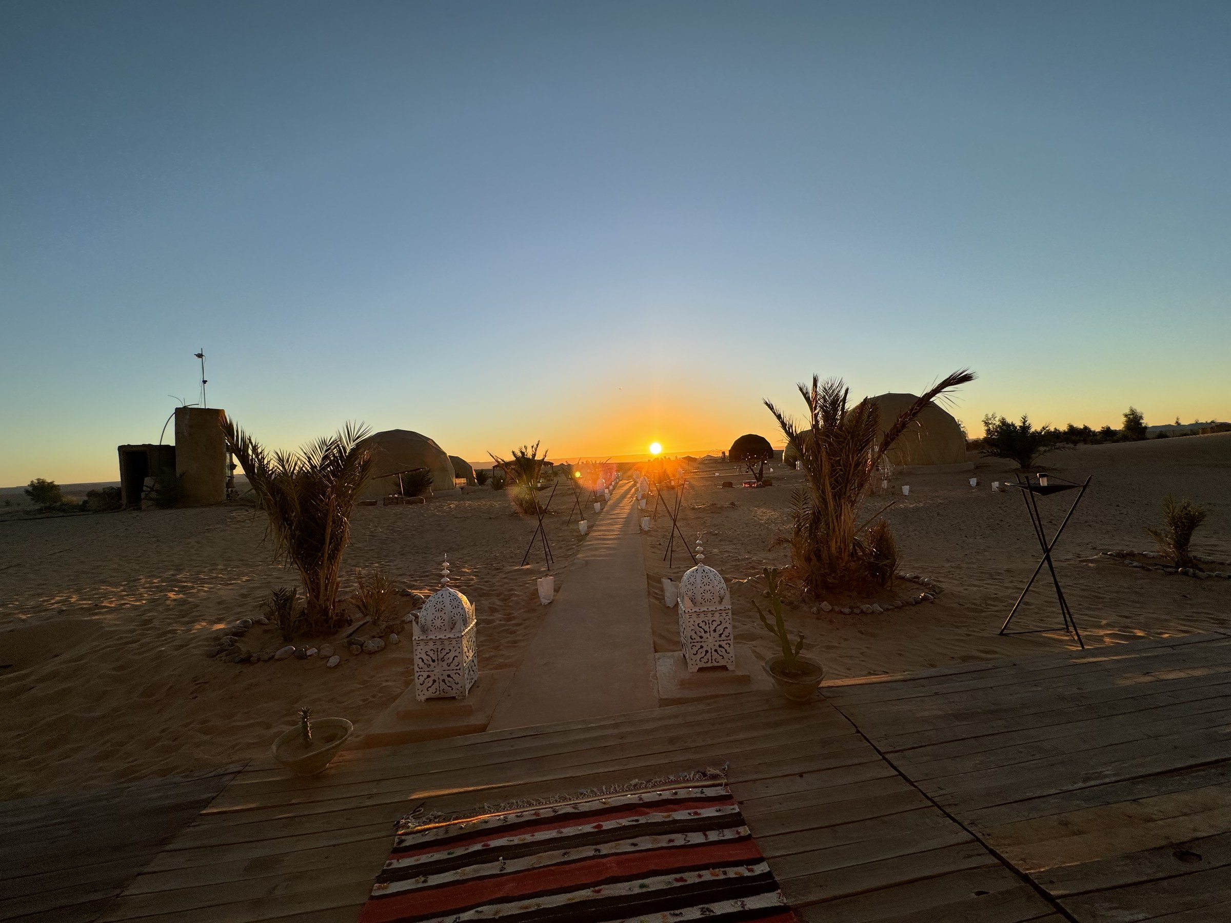 Campamento de lujo en el desierto de Merzouga al atardecer con linternas marroqu&iacute;es y tiendas jaima