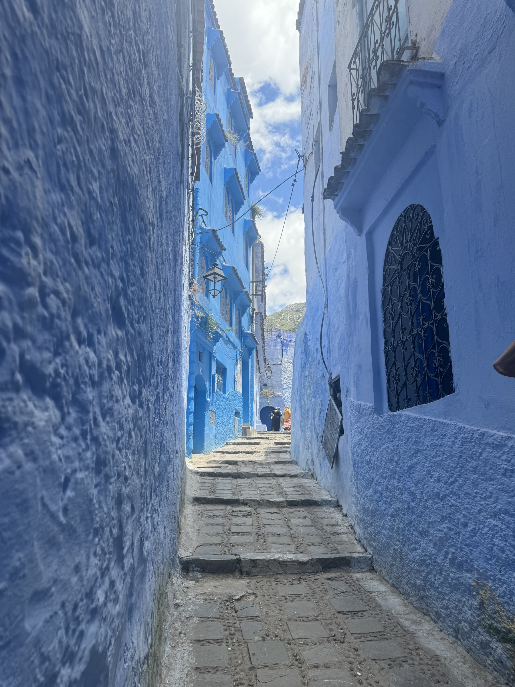 Callej&oacute;n azul de Chefchaouen con escaleras de piedra y paredes pintadas de azul &iacute;ndigo, Marruecos
