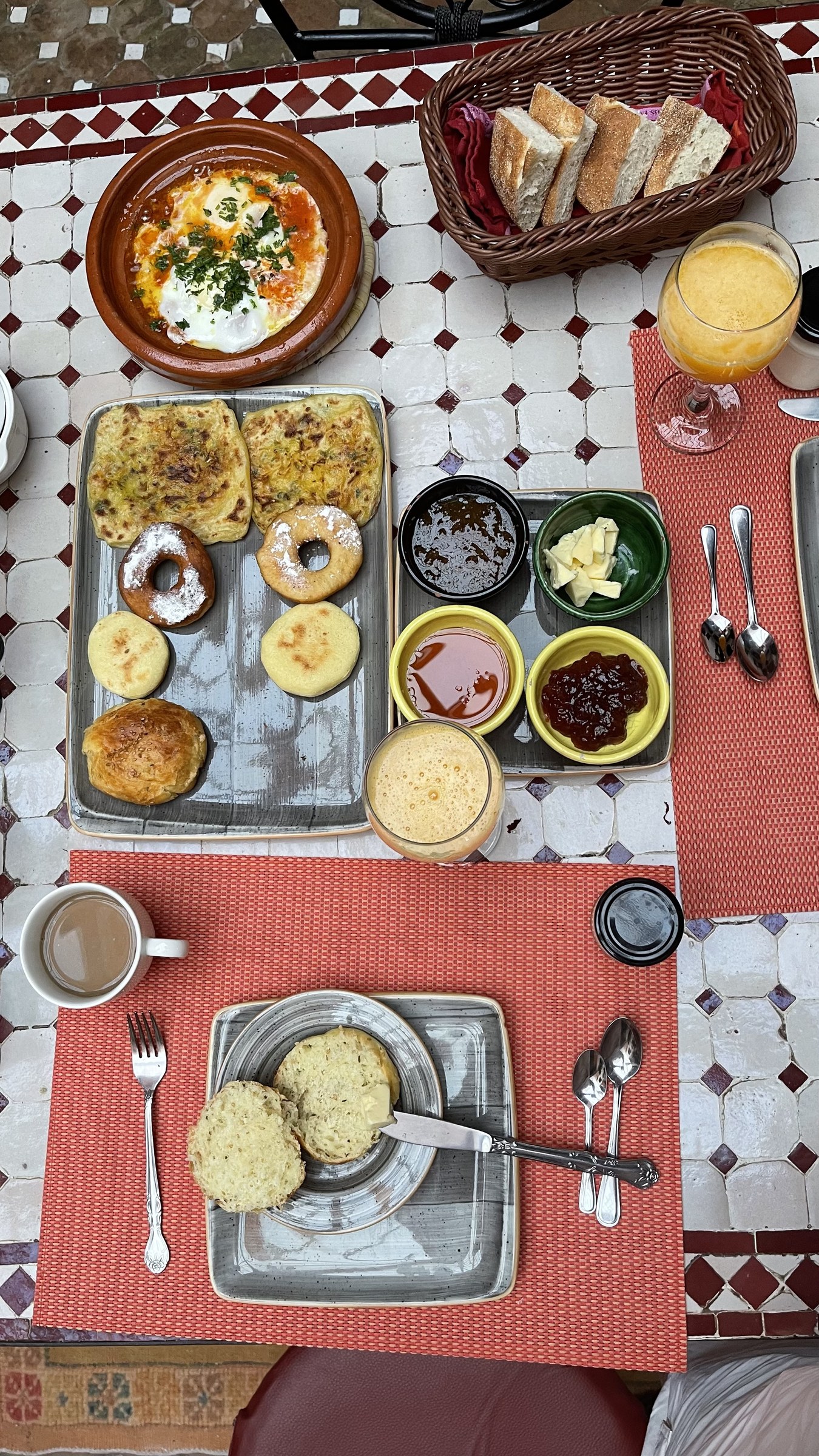 Desayuno marroqu&iacute; tradicional en riad con msemen, beghrir, huevos en tajine, miel y mermelada &mdash; junto al t&eacute;