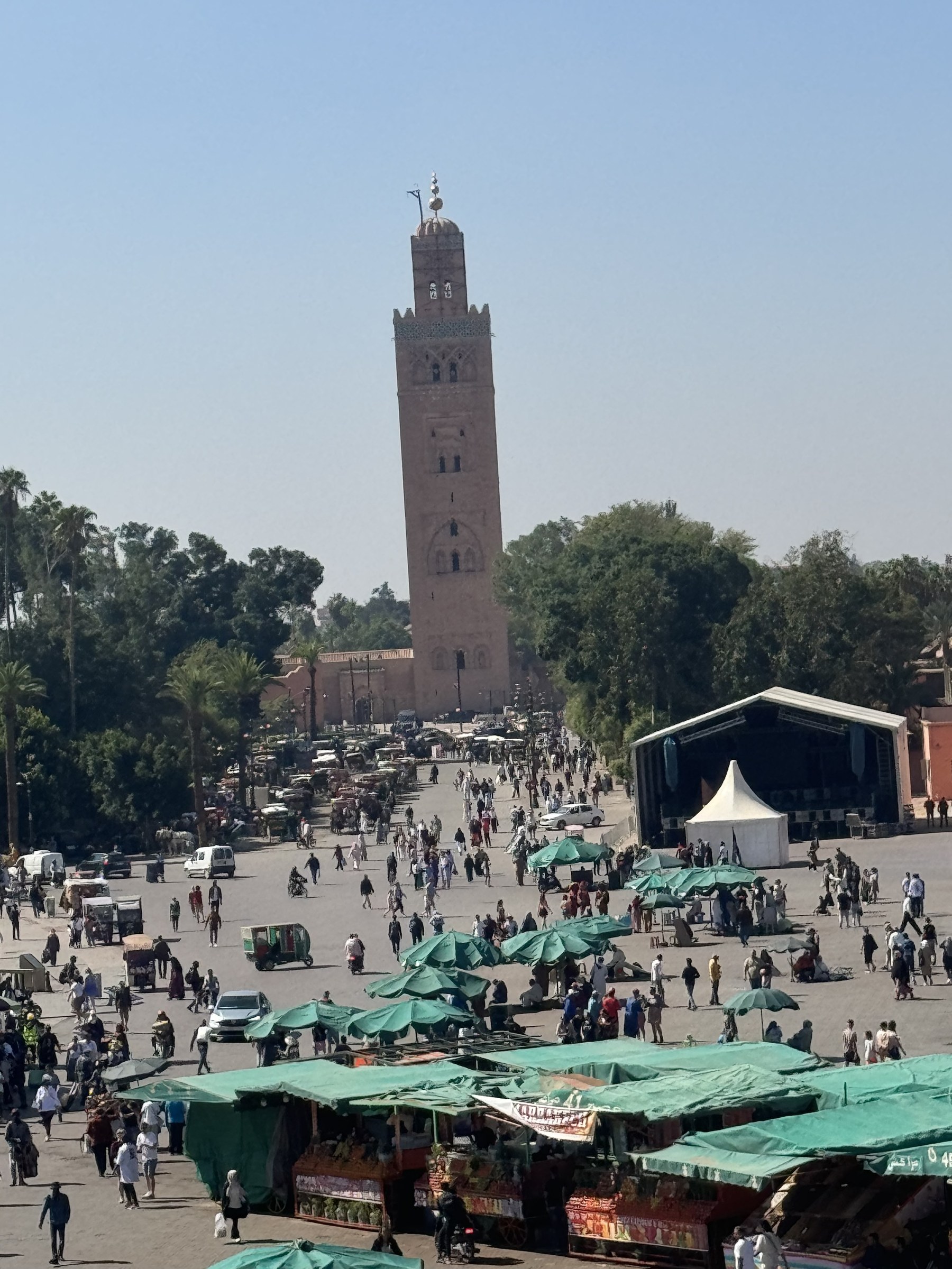 Plaza Jemaa el-Fna de Marrakech con la mezquita Koutoubia al fondo y puestos de mercado